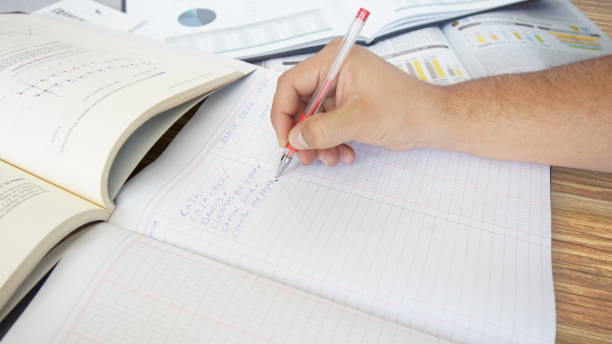 Tips to Complete Accounting Homework Faster Approach to a human hand writing: BANCOS, CUENTAS POR COBRAR, CUENTAS POR PAGAR - BANKS, ACCOUNTS RECEIVABLE, ACCOUNTS PAYABLE in Spanish language - a list of expenses in a ledger on wooden table
