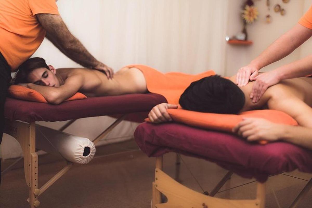 Couple’s Massage in Oakton, VA | Relaxing Spa Experience for Two A relaxing spa scene showing two people receiving side-by-side therapeutic massages on massage tables with orange towels, representing a rejuvenating Couple's Massage in Oakton, VA.