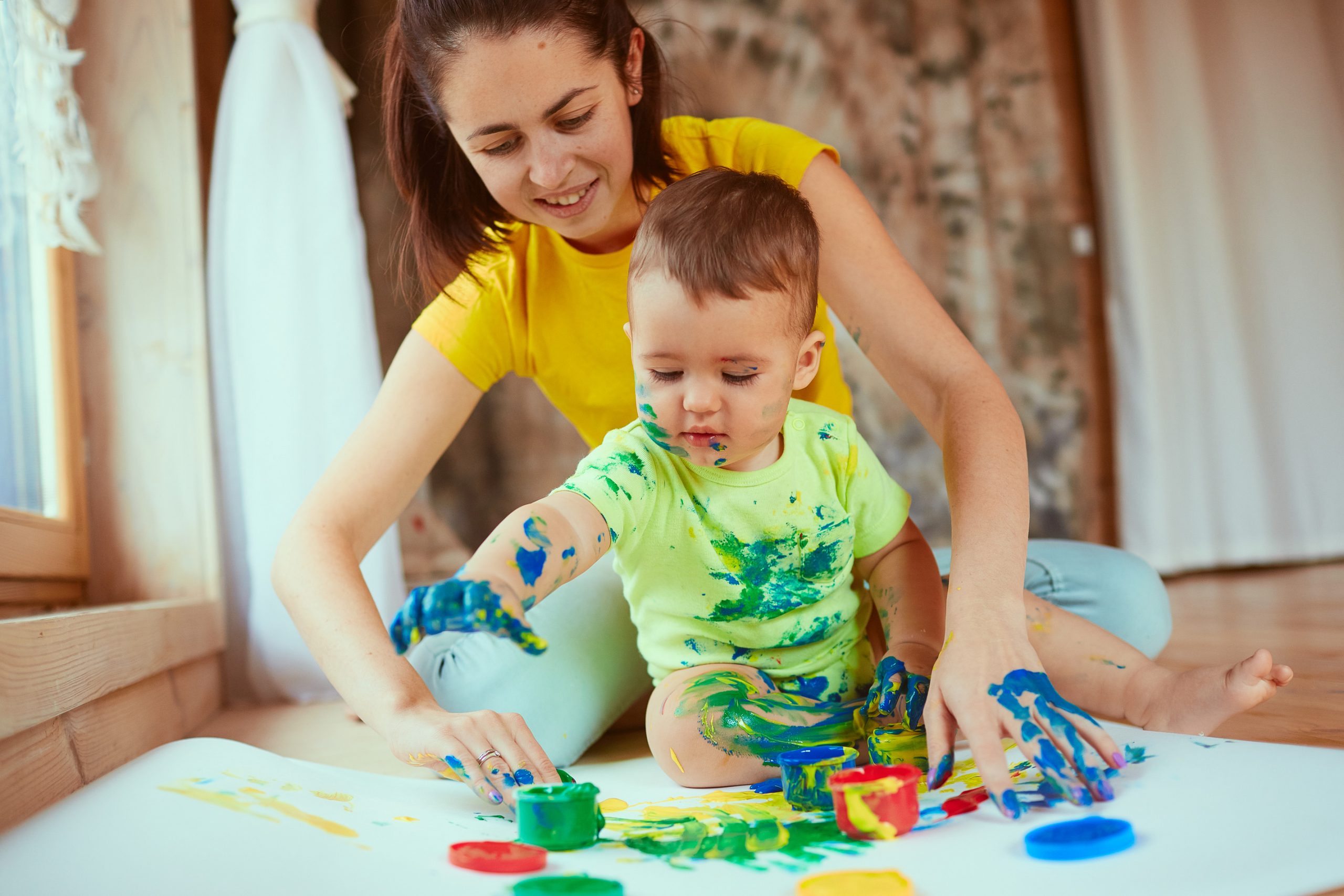 mother-with-son-painting-big-paper-with-their-hands-scaled baby care uae